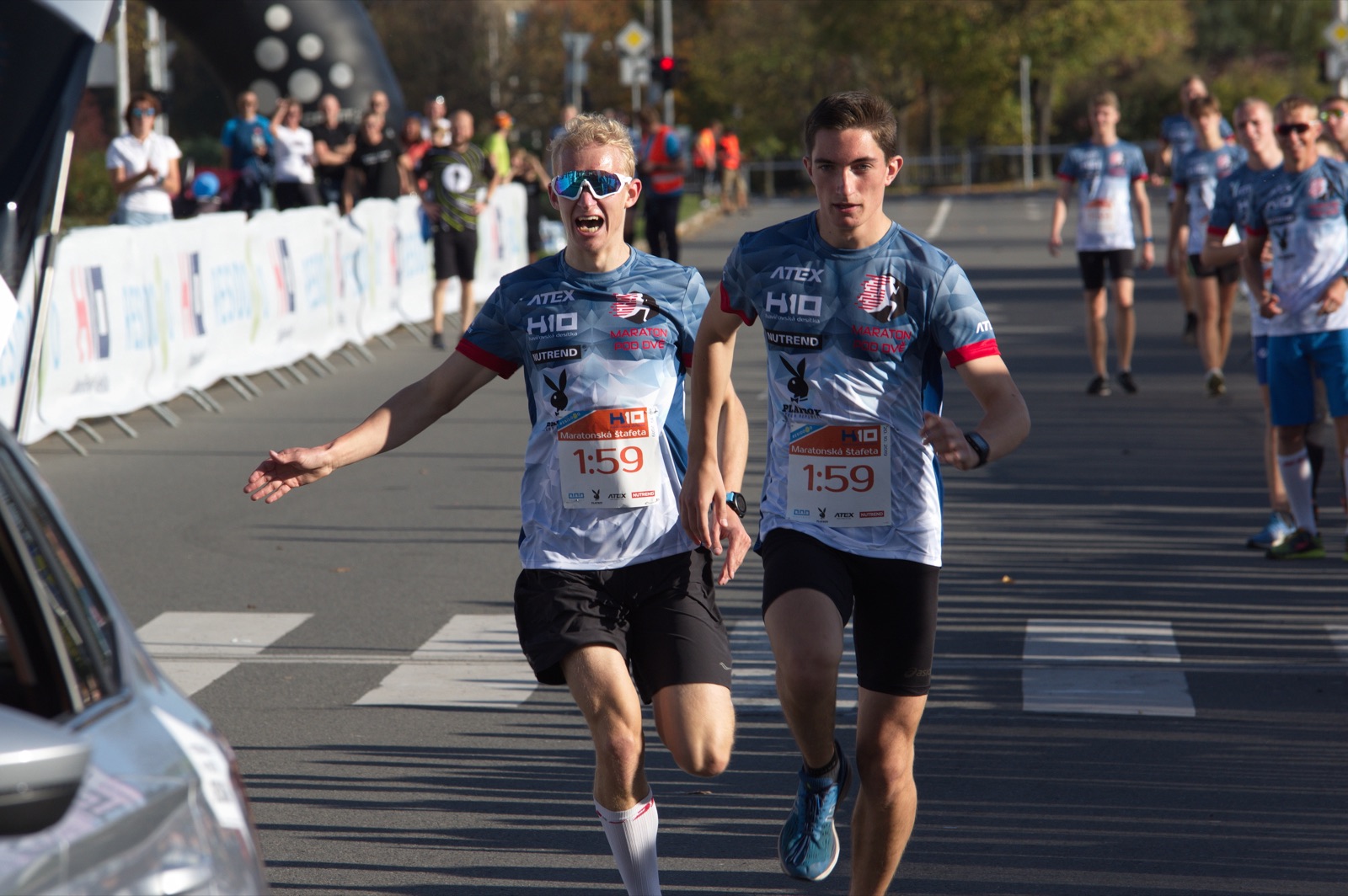 Two relay runners meeting at a handover point during a marathon relay